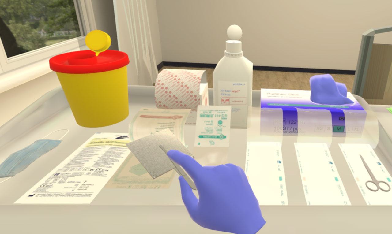 Screenshot from the virtual reality training module on aseptic wound cleansing. What you see is a hand wearing an non-sterile glove, holding a pair of tweezers with a sterile gauze dressing pad. In the background, the top of a dressing cart with various working materials, such as a mouth cover, a pair of scissors and a sharps container, is visible.